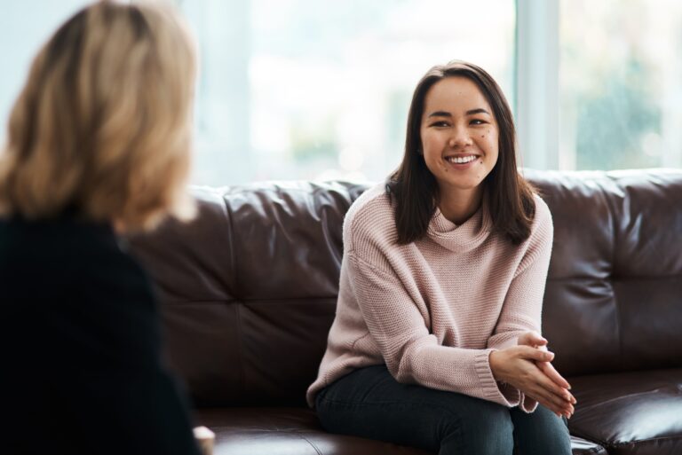 Young woman smiling during an individual counseling session in Flower Mound, TX, receiving professional mental health support.